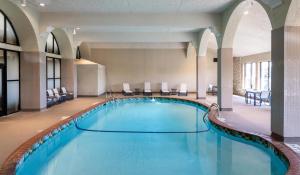 a large pool in a hotel with chairs and tables at Embassy Suites by Hilton Minneapolis Bloomington Edina in Bloomington
