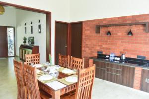 a dining room with a wooden table and chairs at The Pentouz Hillside Chikmagalur in Chikmagalūr