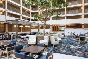an empty lobby of a building with tables and chairs at Embassy Suites by Hilton Minneapolis Bloomington Edina in Bloomington