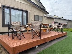 a wooden deck with chairs and a picnic table on it at Villas Park Kamifurano in Kami-furano