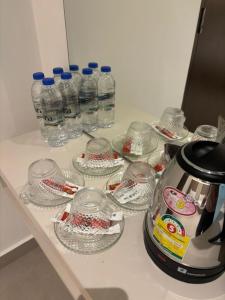 a counter with many glass cups and water bottles at Coastline Hotel 6 Avenue PortDickson in Port Dickson +25 photos