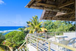a balcony with a table and chairs and the ocean at Peter's Beach House in Poste Lafayette