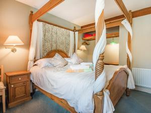 a bedroom with a canopy bed in a room at Ostlers End in Hartington