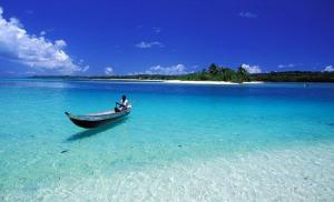 a man sitting in a boat in the ocean at Villa Culture in Ile aux Nattes