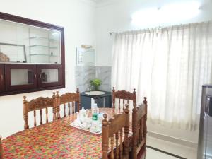 a room with a table and chairs and a window at Aromal Homestay in Kovalam +20 photos