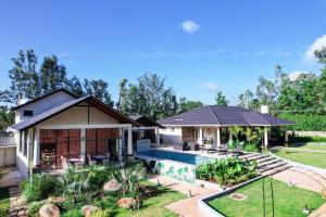 a house with a swimming pool in a yard at The Pentouz Hillside Chikmagalur in Chikmagalūr