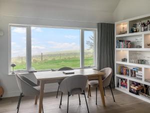 a dining room with a table and chairs and a window at Croft 105 in Melvich