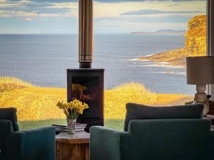 a room with chairs and a view of the ocean at Croft 105 in Melvich
