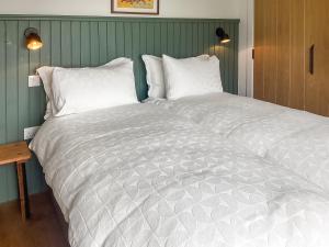 a bedroom with a large bed with white sheets and pillows at Croft 105 in Melvich