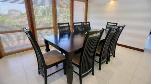 a black table and chairs in a room with windows at White House 101 in Galle +4 photos