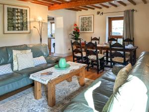 a living room with a couch and a table at Ostlers End in Hartington +9 photos