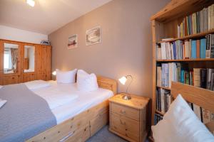 a bedroom with a bed and a book shelf with books at Schnuckeliges Appartement in Sankt Andreasberg