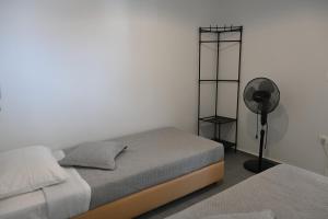 a white room with a bed and a fan at Avra Port House in Porto Heli
