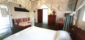 a bedroom with a canopy bed and a dresser at Villa Culture in Ile aux Nattes
