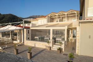 a house with a patio with tables and chairs at Ancora in Skala Potamias