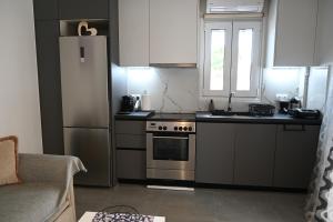 a kitchen with a stainless steel refrigerator and a stove at Avra Port House in Porto Heli