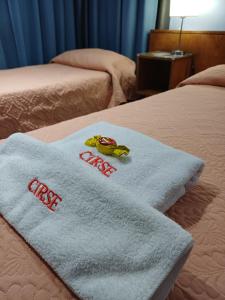 two white towels on top of a bed at Hotel cirse cr in Comodoro Rivadavia +1 photo