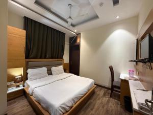 a bedroom with a bed and a desk and a bed sidx sidx sidx at Aura Grand Amritsar in Amritsar +27 photos