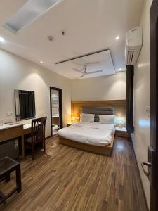 a bedroom with a bed and a desk and a desk at Aura Grand Amritsar in Amritsar