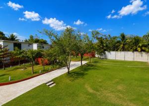 a garden with green grass and trees in front of a building at Dono Pool Villa & Spa in Dauis