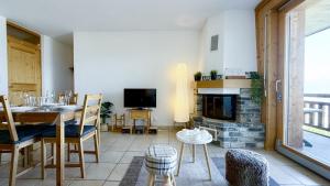 a living room with a table and a fireplace at Plein Ciel VA 022 - MOUNTAIN apartment 4 pers in Veysonnaz