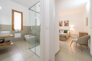a bathroom with a glass shower and a bedroom at Sa concia in Teulada +38 photos