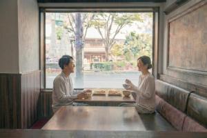 a man and woman sitting at a table in a restaurant at The Celecton Fukushima in Fukushima