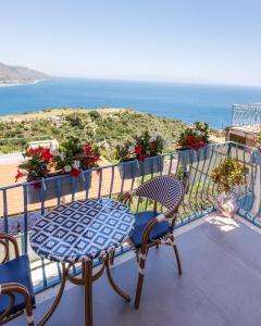a table and chairs on a balcony with a view of the ocean at Athena Charming Rooms in Taormina