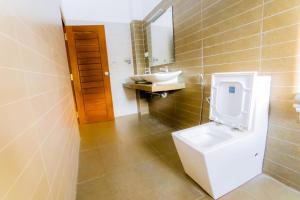 a bathroom with a toilet and a sink and a mirror at White House 101 in Galle