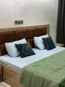 a bed with two pillows on top of it at PLV Apartment in Ilorin