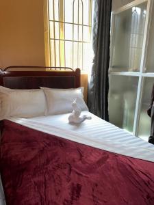 a stuffed animal sitting on top of a bed at Zone hotel and guest house in Bugembe