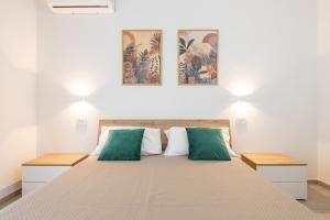 a bedroom with a bed with green and white pillows at Sa concia in Teulada