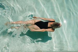 Eine Frau treibt auf einem Schwimmbecken in der Unterkunft Hotel Helios Lloret in Lloret de Mar