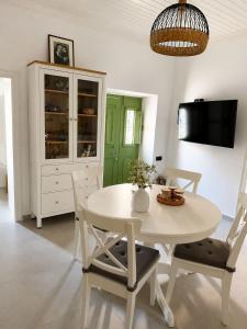 a white dining room with a white table and chairs at Villa Elli in Halki
