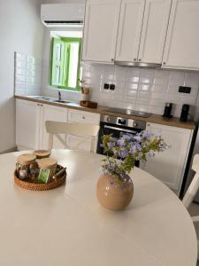 a white kitchen with a vase of flowers on a table at Villa Elli in Halki