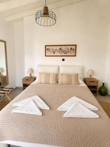 a bedroom with a large bed with white towels on it at Villa Elli in Halki