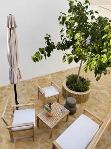 a patio with a table and chairs and a tree at Villa Elli in Halki +9 photos