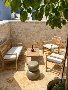 a patio with two benches and a table and chairs at Villa Elli in Halki