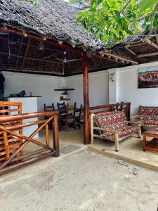a room with chairs and tables and a thatched roof at vayana nungwi in Nungwi +18 photos