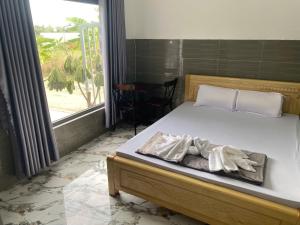 a bedroom with a bed and a large window at Khách sạn Hotel 6 in Ấp Tân Thành