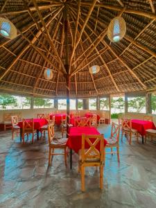 a restaurant with red tables and chairs and a large ceiling at Emaamara camp in Narok