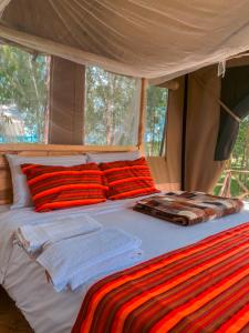 a bed in a tent with towels on it at Emaamara camp in Narok