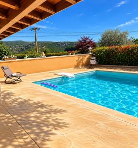 a swimming pool with a chair next to a house at gîte les muriers in Lagorce +12 photos