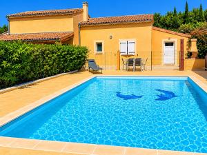 two dolphins swimming in a swimming pool in front of a house at gîte les muriers in Lagorce