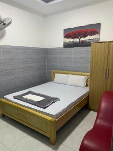 a bedroom with a bed and a red chair at Khách sạn Hotel 6 in Ấp Tân Thành