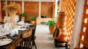 a dining room with a table and chairs and a room with plants at Skojet Boutique Hotel in Ruhengeri