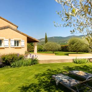 a garden with a bench and a house at gîte les muriers in Lagorce