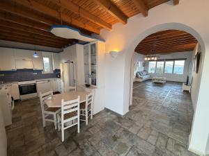 a kitchen and dining room with a table and chairs at The Aegean Horizon Villa in Grótta