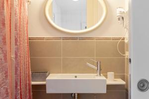 a bathroom with a white sink and a mirror at Appartamento Il Nespolo in Pontedera