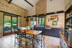 a kitchen with a wooden table and chairs in it at Gite Le Mas in Corgnac-sur-lʼIsle